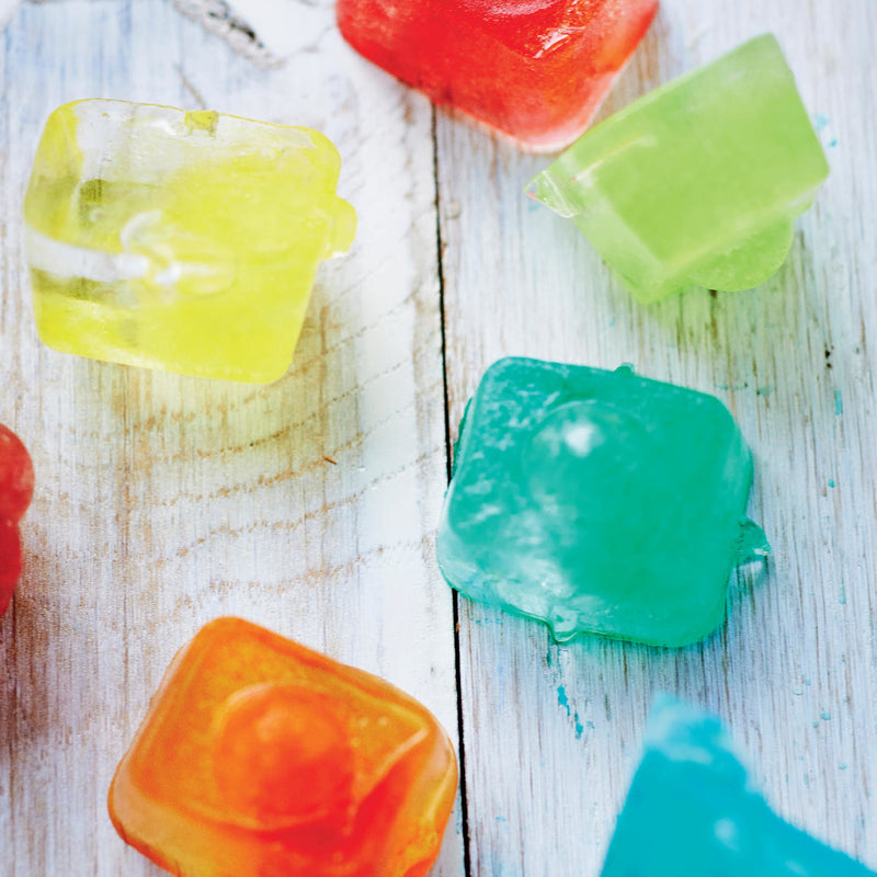 Colorful reusable ice cubes on a rustic wooden surface, kitchen accessories.
