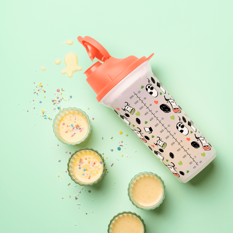 Tupperware Shaker 600 ml with cow print and orange lid on a light green background.