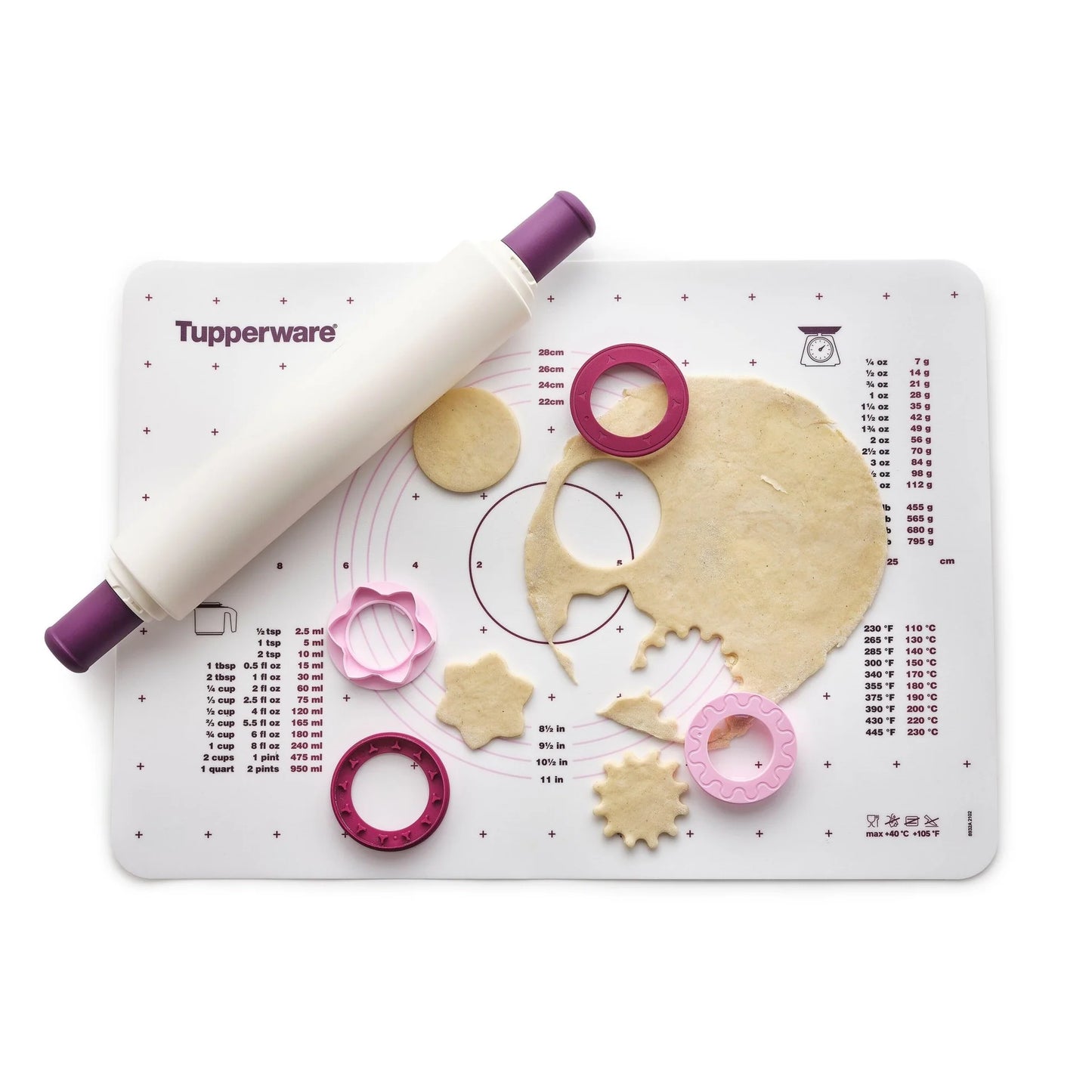 Baking mat with measurements, white rolling pin, dough, and assorted cookie cutters