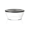 Transparent food storage container with black lid on white background