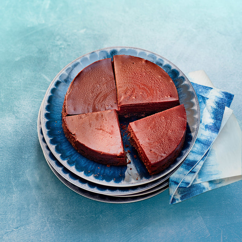 Sliced chocolate cake on a blue patterned plate with a blue and white napkin.