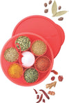 Round red spice box with compartments of assorted spices and a matching red lid