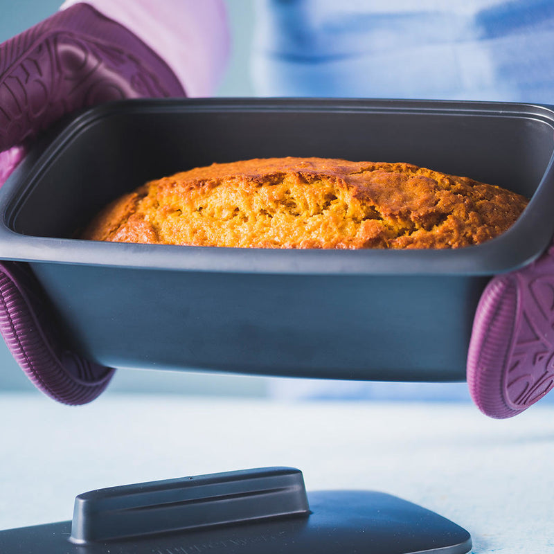 Freshly baked bread in a Tupperware UltraPro Terrine held with purple oven mitts