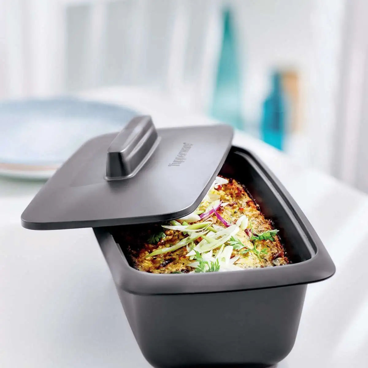 Tupperware UltraPro Terrine 1.8L with lid, containing a baked dish topped with fresh greens.
