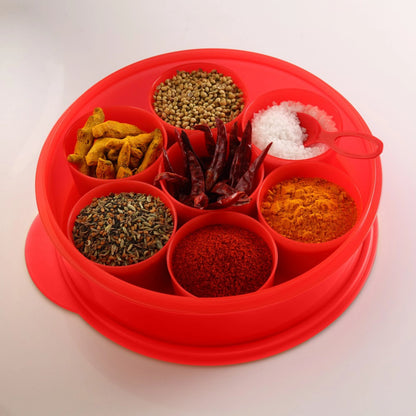 Red plastic spice box with seven compartments filled with assorted spices and salt