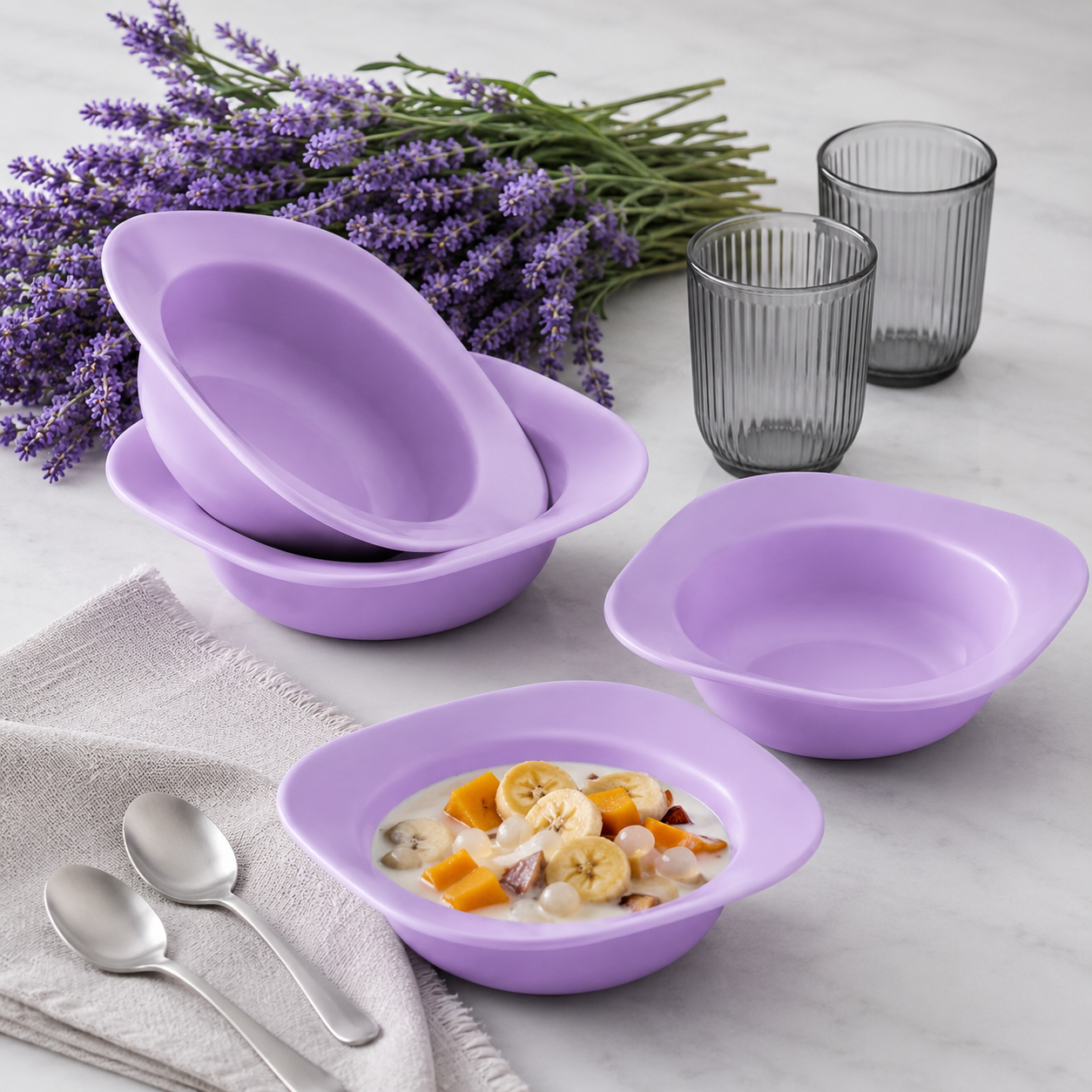 Paarse keukenschalen met fruit en melk, perfect voor ontbijt of dessert, met lavendel en glazen op marmeren tafel