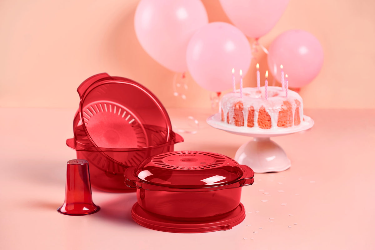 Rode Tupperware Combo Micro 3 set naast een feestelijke taart met roze ballonnen