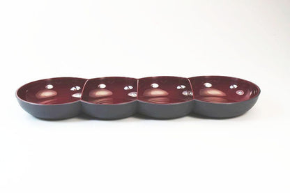 Four-section maroon and black ceramic serving dish on white background