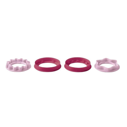 Set of four round and star-shaped pink plastic cookie cutters on white background