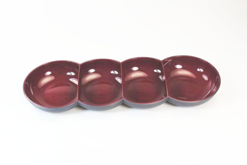 Four-section maroon ceramic appetizer serving dish on white background