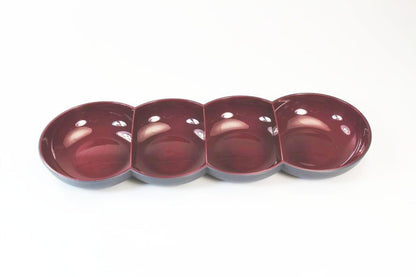 Four-section maroon ceramic appetizer serving dish on white background
