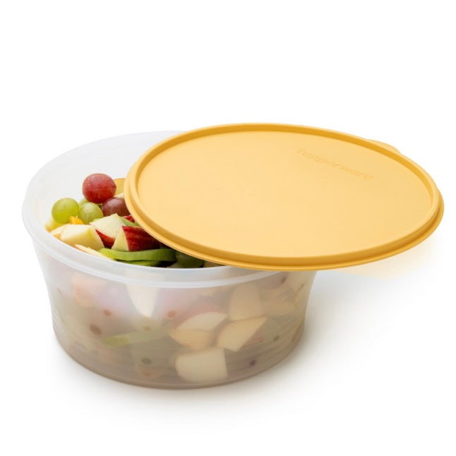 Transparante voedselcontainer met gele deksel, gevuld met fruit zoals druiven en appelstukjes