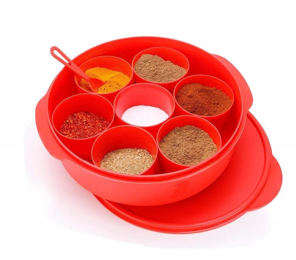 Red plastic spice box with seven compartments, assorted spices, and small spoon