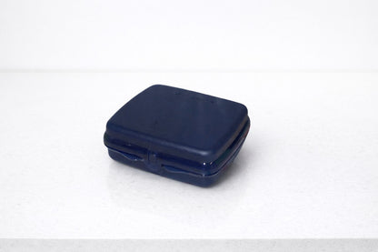 Closed dark blue plastic sandwich box on a white countertop