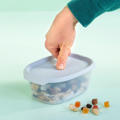 Hand opent transparante opbergdoos met noten en gedroogd fruit, ideaal voor keukentools