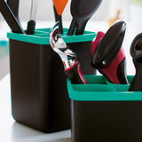 Modern kitchen utensils in black containers with turquoise edges on countertop