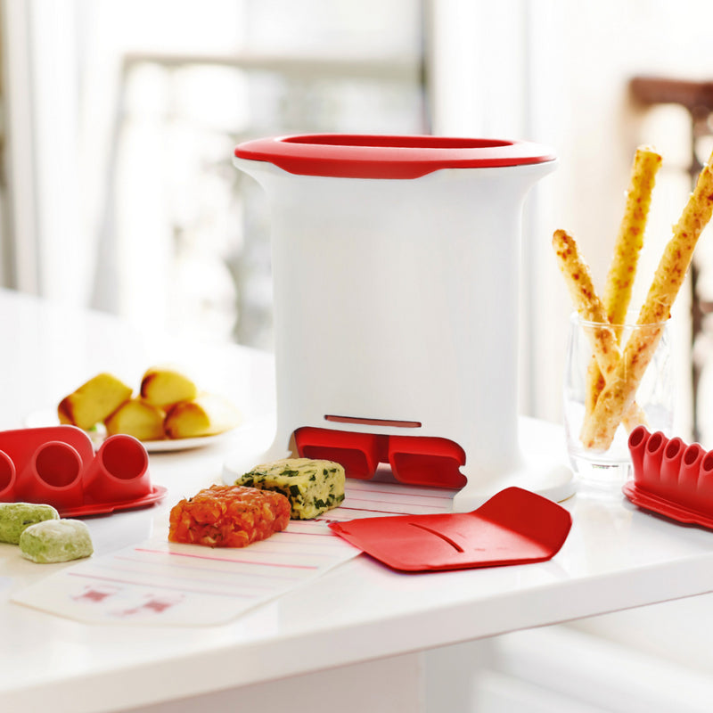 Multi-purpose kitchen tool with red accents on a counter, surrounded by shaped food and baking accessories.