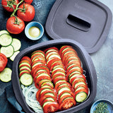 Nonstick baking dish with layered tomato and zucchini slices, onions, fresh vegetables