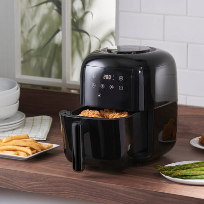 Black digital air fryer with chicken and fries on a kitchen counter, modern kitchen setting