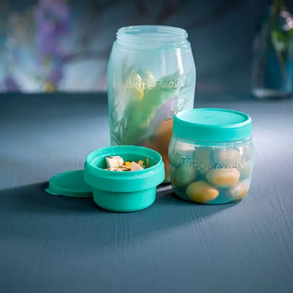 Turquoise Tupperware opbergpotten met groenten en noten, ideaal voor keukenorganisatie en frisse ingrediënten