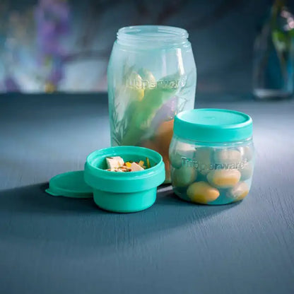 Turquoise Tupperware opbergpotten met groenten en noten, ideaal voor keukenorganisatie en frisse ingrediënten