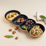 Black and gold Tupperware divided serving bowl with hummus, walnuts, grapes, and pinwheels