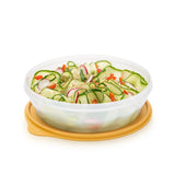 Round plastic food storage container with yellow lid, filled with fresh salad