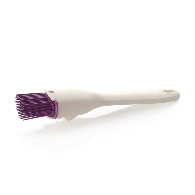 White silicone pastry brush with purple bristles on a white background, kitchen accessory