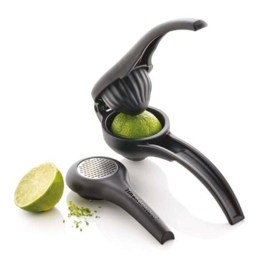 Black handheld citrus press and grater with fresh lime, kitchen gadget on white background.
