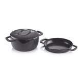 Black cast iron Dutch oven with lid and matching shallow pan, isolated on white background