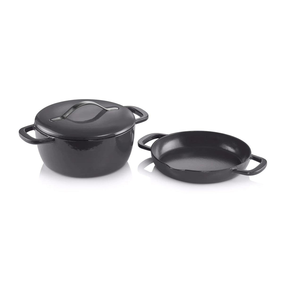 Black cast iron Dutch oven with lid and matching shallow pan, isolated on white background