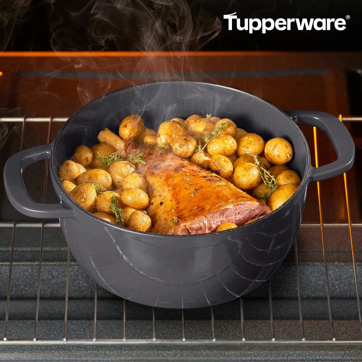 Black cast iron Dutch oven with roast and potatoes in an oven, steam rising