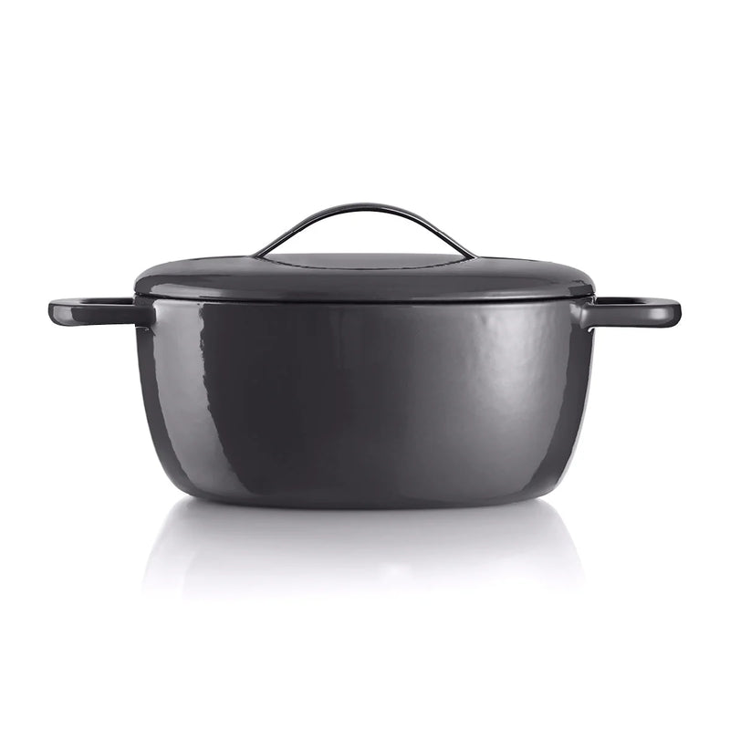 Black cast iron Dutch oven with lid and handles on white background