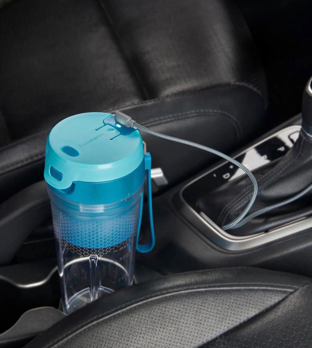Blue leakproof water bottle with carry strap in a car cup holder