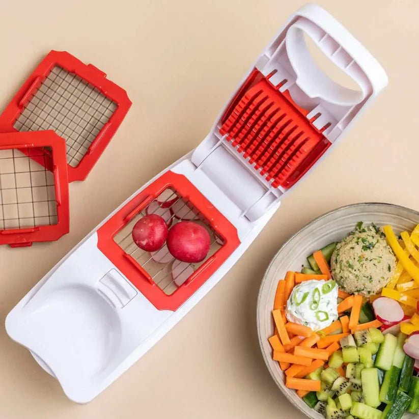Vegetable chopper with interchangeable blades and fresh salad ingredients on table