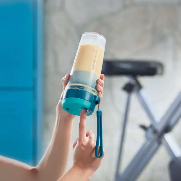 Hand houdt draagbare blender met smoothie, perfect voor keuken en onderweg, premium keukengadget