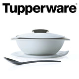 Witte Tupperware serveerschaal met transparant deksel, onderzetter en zwarte serveerlepel
