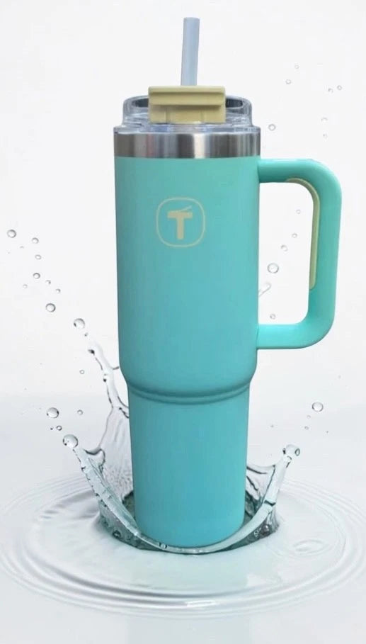 Blue insulated tumbler with handle and straw, splashing into water, leakproof travel cup