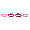 Set of four round and star-shaped pink plastic cookie cutters on white background