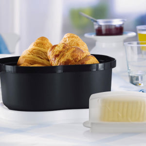 Zwarte broodmand met verse croissants op keukentafel, perfect voor ontbijt of brunch