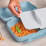 Hand opening a light blue Tupperware Snackpack filled with pasta and basil.