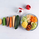 Vegetable spiralizer with raw veggies and spiralized vegetable noodles on a plate