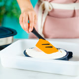 Tupperware Micro Pro Grill Ring with orange spatula spreading white sauce in a white dish.