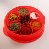 Red plastic spice box with seven compartments filled with assorted spices and salt