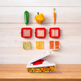 Tupperware Super Dicer with various blade inserts and diced vegetables on a white wooden background
