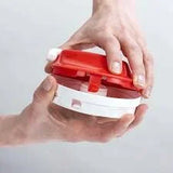 Hands holding a round red and white kitchen gadget for food preparation