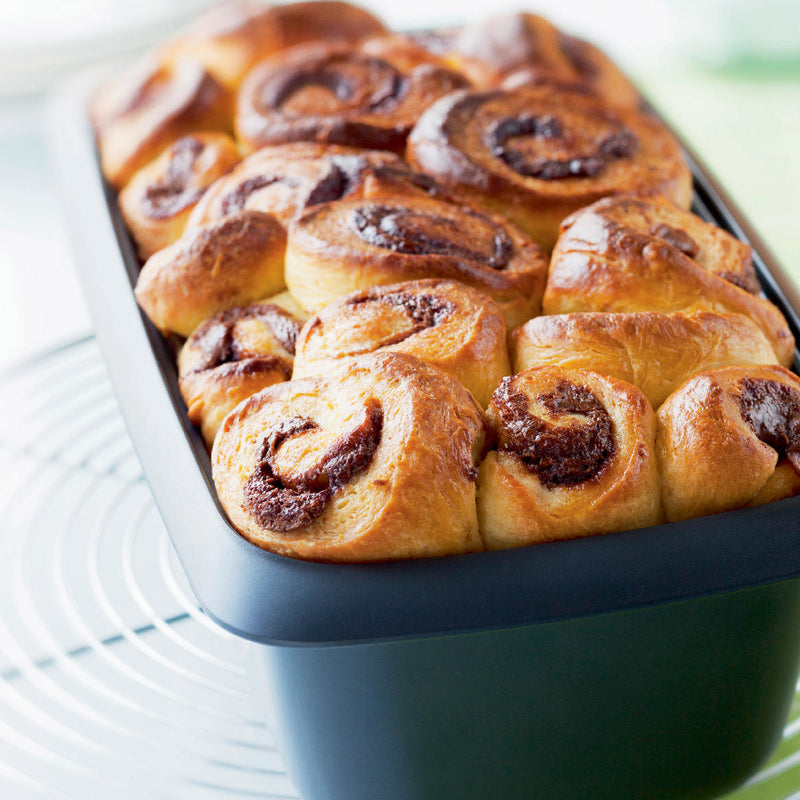 Freshly baked cinnamon rolls in a Tupperware UltraPro Terrine baking dish.