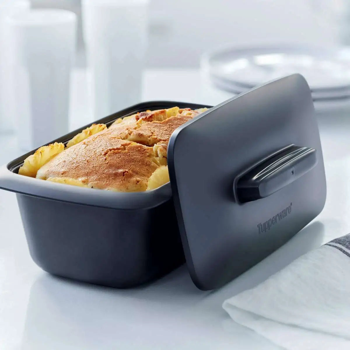 Tupperware UltraPro Terrine containing a golden-brown baked dish with its lid partially open.