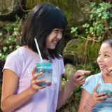 Two girls smiling and drinking from Tupperware Universal Jars outdoors.