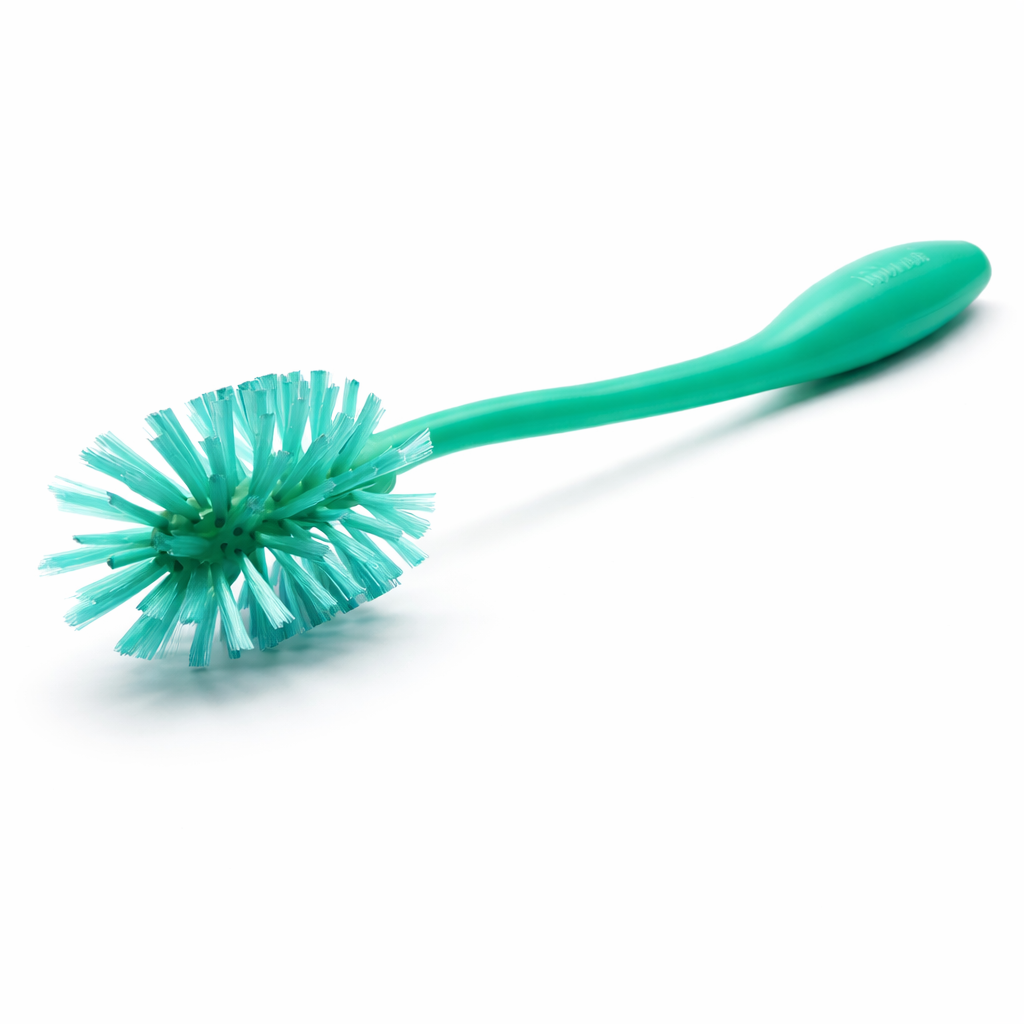 Green kitchen cleaning brush with ergonomic handle and round bristle head on white background